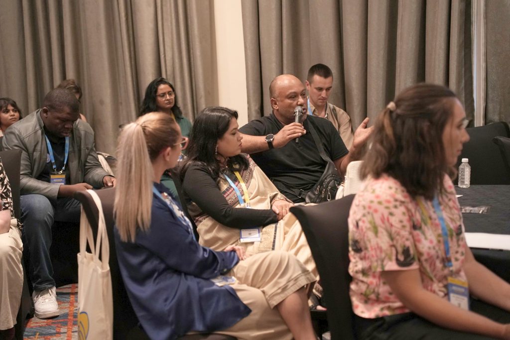 group of attendees gathered together during the welcome night at the Global Summit to End Diabetes Stigma. The group poses smiling in a hotel conference space in front of EndDiabetesStigma.org display boards.